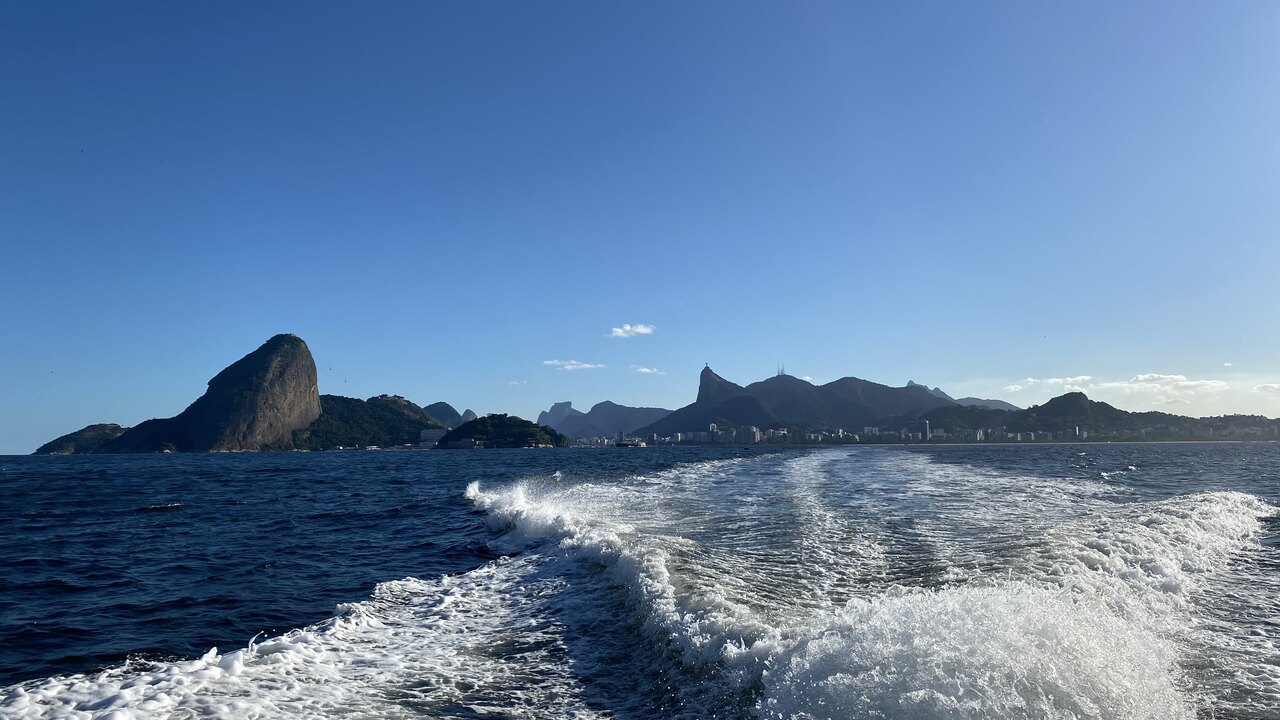 Céu azul sobre a Baía de Guanabara com lancha navegando em condições ideais