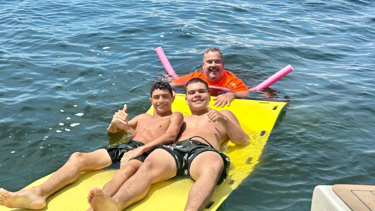 Família com crianças curtindo passeio de lancha na Baía de Guanabara com Pão de Açúcar ao fundo
