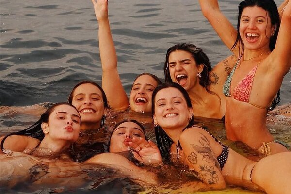 Grupo de amigas se divertindo na água com tapete flutuante durante passeio de Carnaval