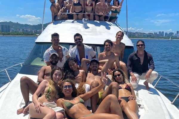 Grande grupo curtindo Carnaval na lancha com vista panorâmica do Rio