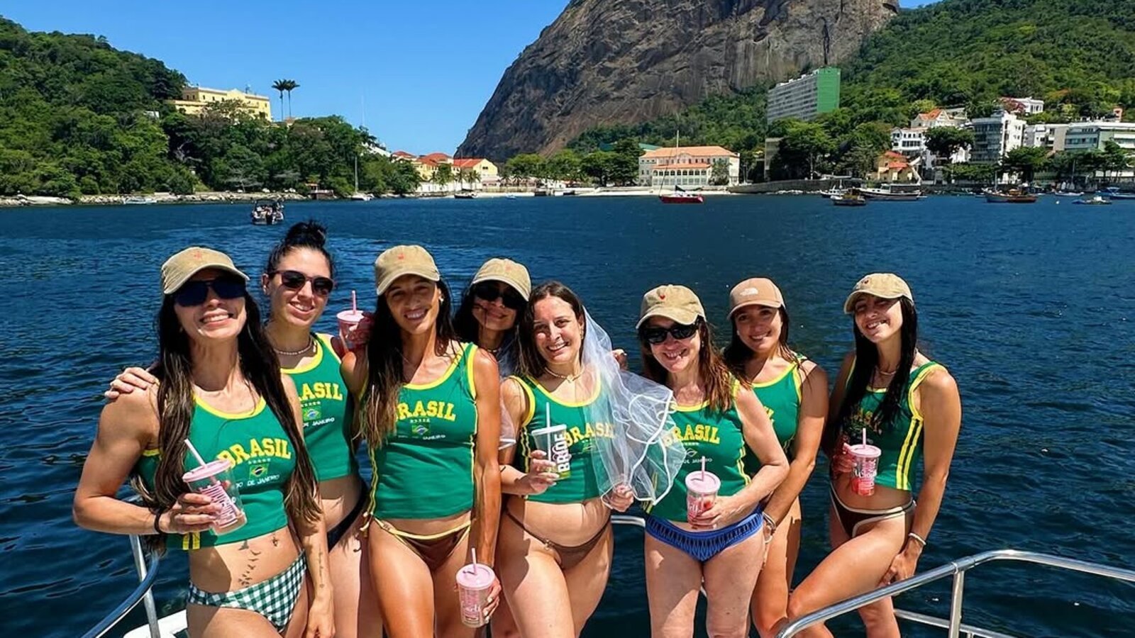 Grupo de amigas com camisas do Brasil curtindo Carnaval na lancha com Pão de Açúcar ao fundo