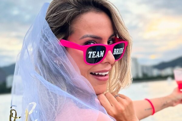 Noiva com véu e óculos Team Bride na despedida de solteira na lancha