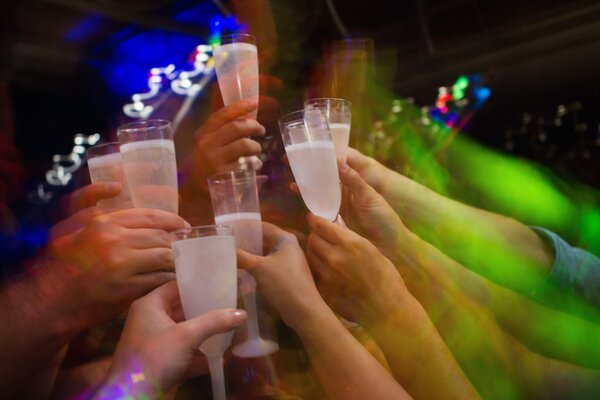 Brinde com taças de champanhe e luzes coloridas na festa de réveillon na lancha