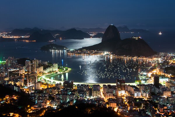Vista noturna da Baía de Guanabara com Pão de Açúcar e Botafogo iluminados