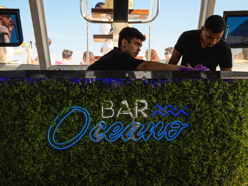 Bar Oceano a bordo com bartenders preparando drinks durante passeio de lancha