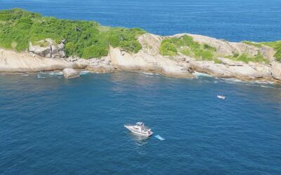 Vista aérea das Ilhas Cagarras com lancha ancorada em águas cristalinas