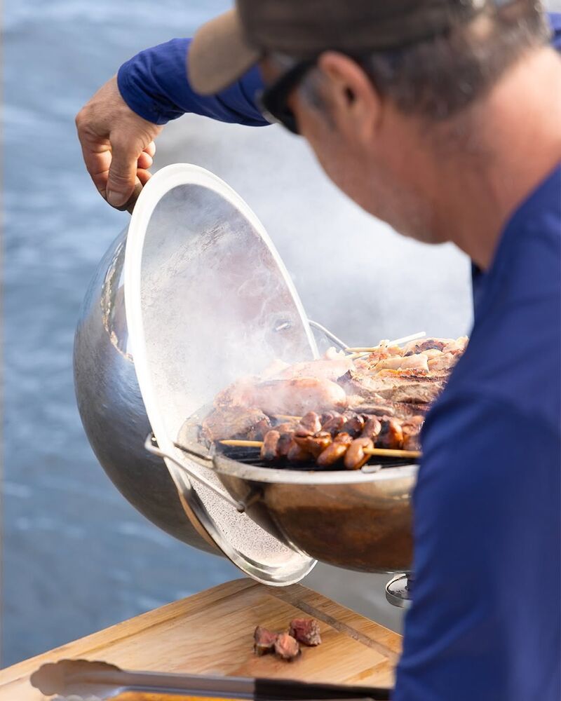 Churrasco sendo preparado na lancha com vista para o mar