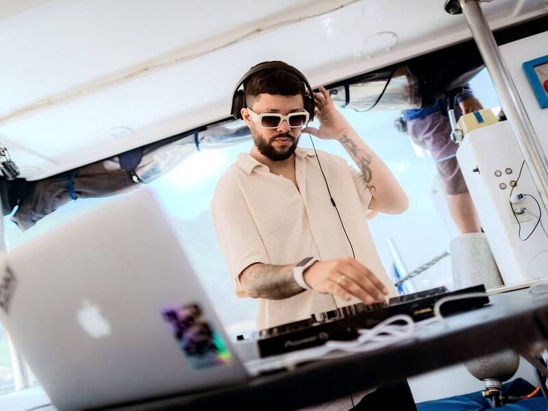 DJ profissional com headphones e controladora na lancha