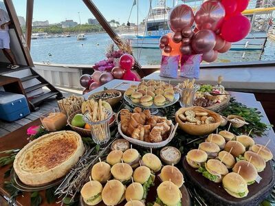Mesa de snacks premium na lancha com mini sanduíches, canapés e finger foods