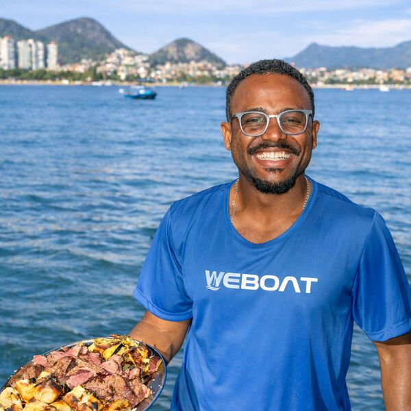 Membro da equipe WeBoat servindo churrasco a bordo da lancha