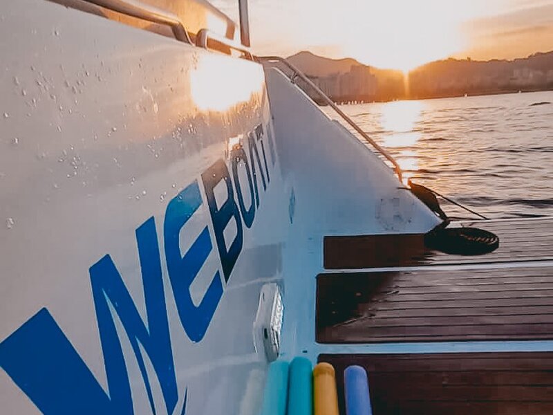 Lancha WeBoat com logo ao pôr do sol na Baía de Guanabara